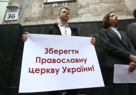 Активист держит плакат с надписью