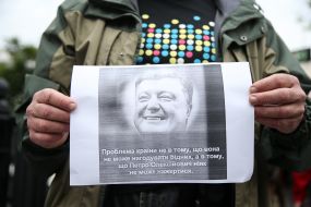 Плакат с портретом Петра Порошенко в руках у участника акции