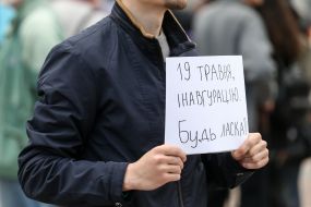 Плакат с надписью "19 мая, инаугурацию" в руках у участника акции
