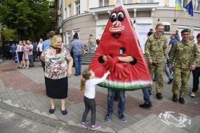Дівчинка біля людини в костюмі кавуна