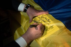 Petro Poroshenko puts an autograph on the flag of Ukraine