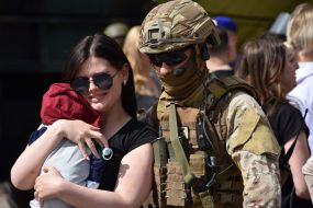 A woman with a child near a soldier