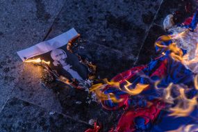 The photo of Vladimir Putin and the flag of Russia in the fire