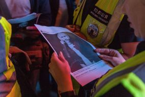 The law-enforcement officer reads an inscription under Vladimir Putin's photo on the poster