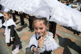 Ученица младших классов с зонтиком от солнца