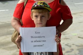 The boy holds a poster
