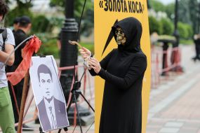 Participant in the performance in the costume of death at the portrait of Vladimir Groisman