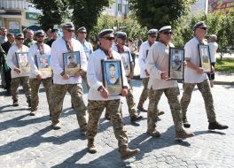 Servicemen carry portraits of dead fellows