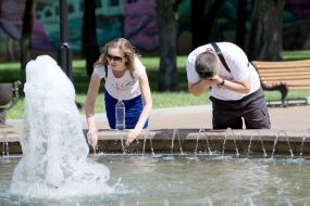 Люди умываются в фонтане