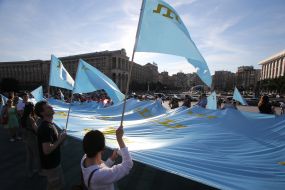 Rally participants hold the Crimean Tatar flag