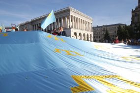 Rally participants hold the Crimean Tatar flag