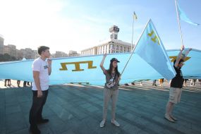 Rally participants hold the Crimean Tatar flag