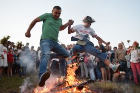 Young people jump over the fire