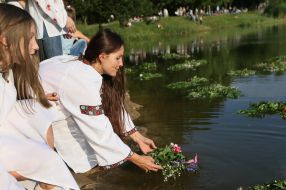 Girls in embroidery wreaths of wild flowers in the water