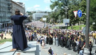 Priest takes pictures of participants of the procession