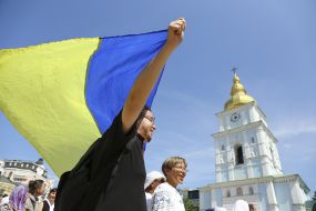 Участник Крестного хода верующих ПЦУ с флагом Украины