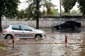 Автомобили передвигаются по затопленной улице