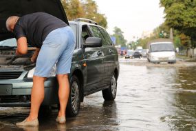 Водитель ремонтирует автомобиль