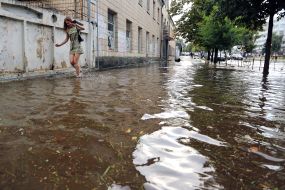 Девушка идет по залитой водой улице