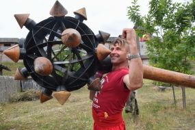 Мужчина в национальном украинском костюме держит на плече огромную булаву