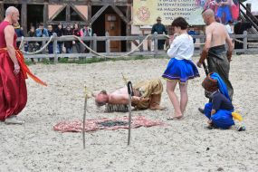 Мужчина в национальном украинском костюме лежит на гвоздях