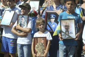 Children hold portraits of the dead