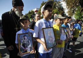 Children carry portraits of the dead military