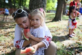 Дівчинка з мамою їдять кавуни