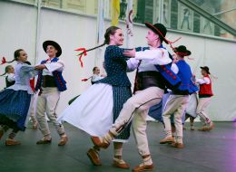 Участники фестиваля в этнических костюмах танцуют