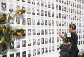 Жінка біля меморіалу «Стіна народної пам’яті»