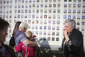 Жінка біля меморіалу «Стіна народної пам’яті»