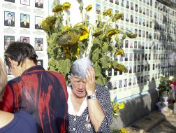 Жінка біля меморіалу «Стіна народної пам’яті»