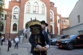 Ephraim Cap holding a scroll of the Torah