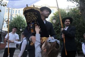 Ephraim Cap holding a scroll of the Torah