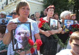 Women hold photos of fallen servicemen