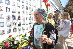 Женщина держит фотографию погибшего военнослужащего