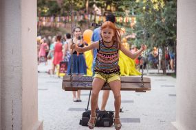 Little girl with red hair goes on a swing