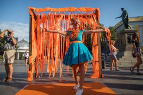 A participant in the parade of redheads in a red wig and carnival costume