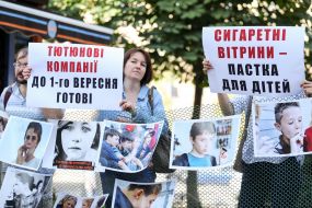 The protesters with placards near the tobacco kiosk