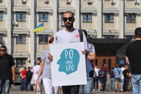 Участник митинга держит плакат