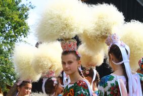 Girls in high hats of feather grass