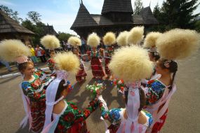 Girls in high hats of feather grass