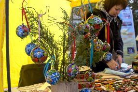 The branch of thuja is decorated with painted Christmas tree decorations