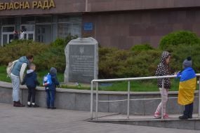 Женщина с детьми возле памятного знака "Героям революции достоинства"