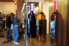 Пляшки з винами у скляних вітринах