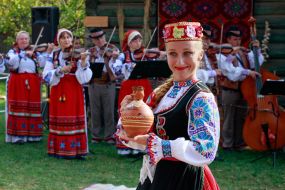 Участница Заслуженного академического Закарпатского народного хора держит глиняный кувшин в руках