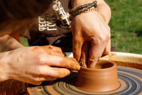 Гончар учит мальчика работать с глиной