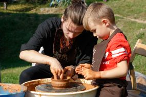 Гончар учит мальчика работать с глиной