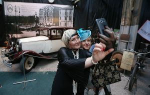 Visitors to the museum take selfies against the backdrop of a retro car
