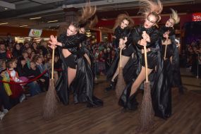 Women in witch costumes dance on stage